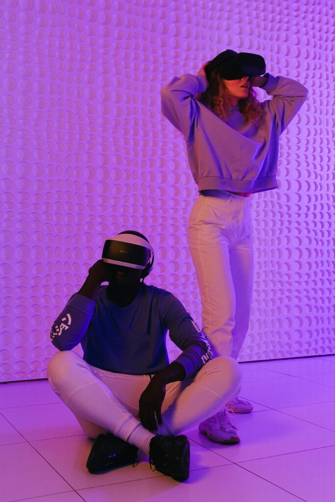 Two people enjoying virtual reality with futuristic lighting and headphones.