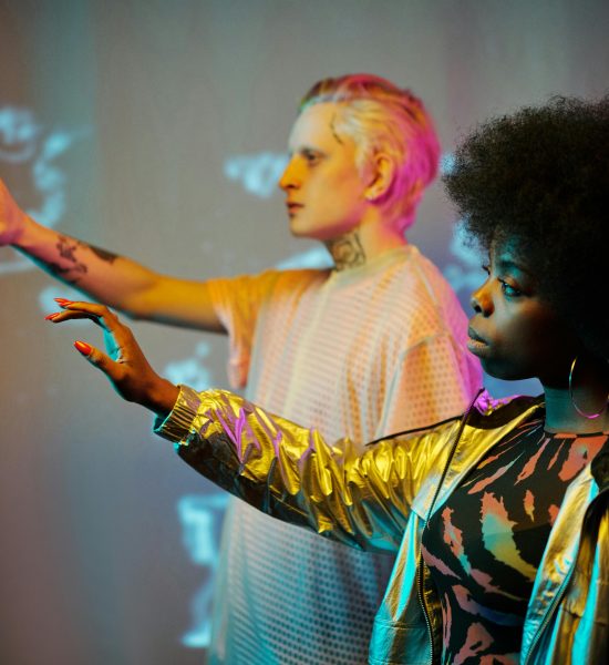 Two adults interacting with virtual screens in futuristic setting.