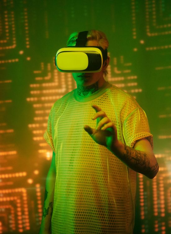 Person immersed in virtual reality, illuminated by vibrant lights, in a futuristic tech environment.