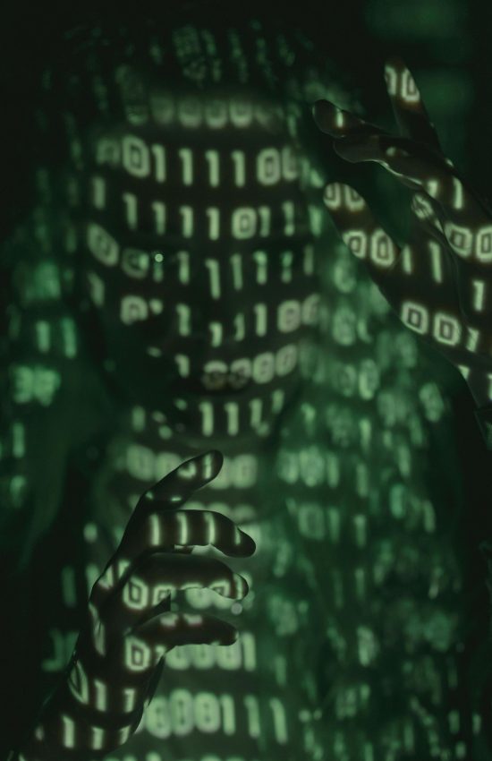 An unrecognizable person with binary code projected, symbolizing cybersecurity and digital coding.