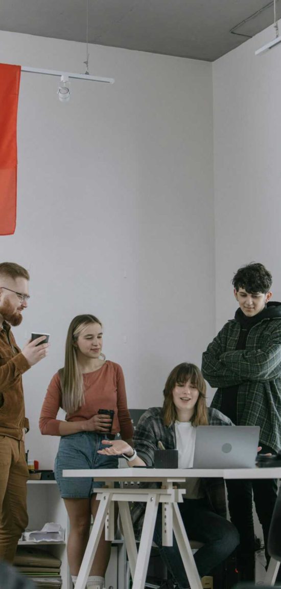 A group of young professionals engaged in a collaborative meeting in a modern office setting.