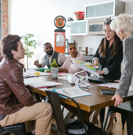 Colleagues engaged in a collaborative business meeting around a table in a modern office setting.